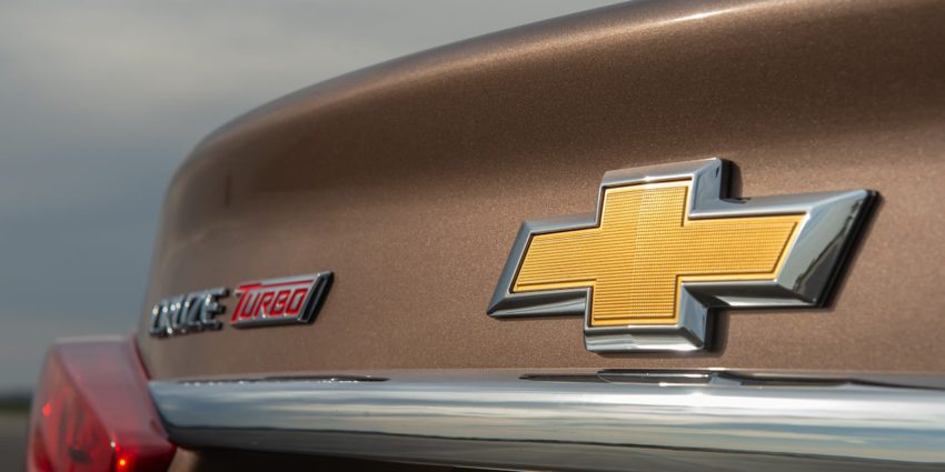 Logo da Chevrolet em traseira de um Cruze bege