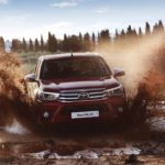 Toyota Hilux vinho passando por lamaçal